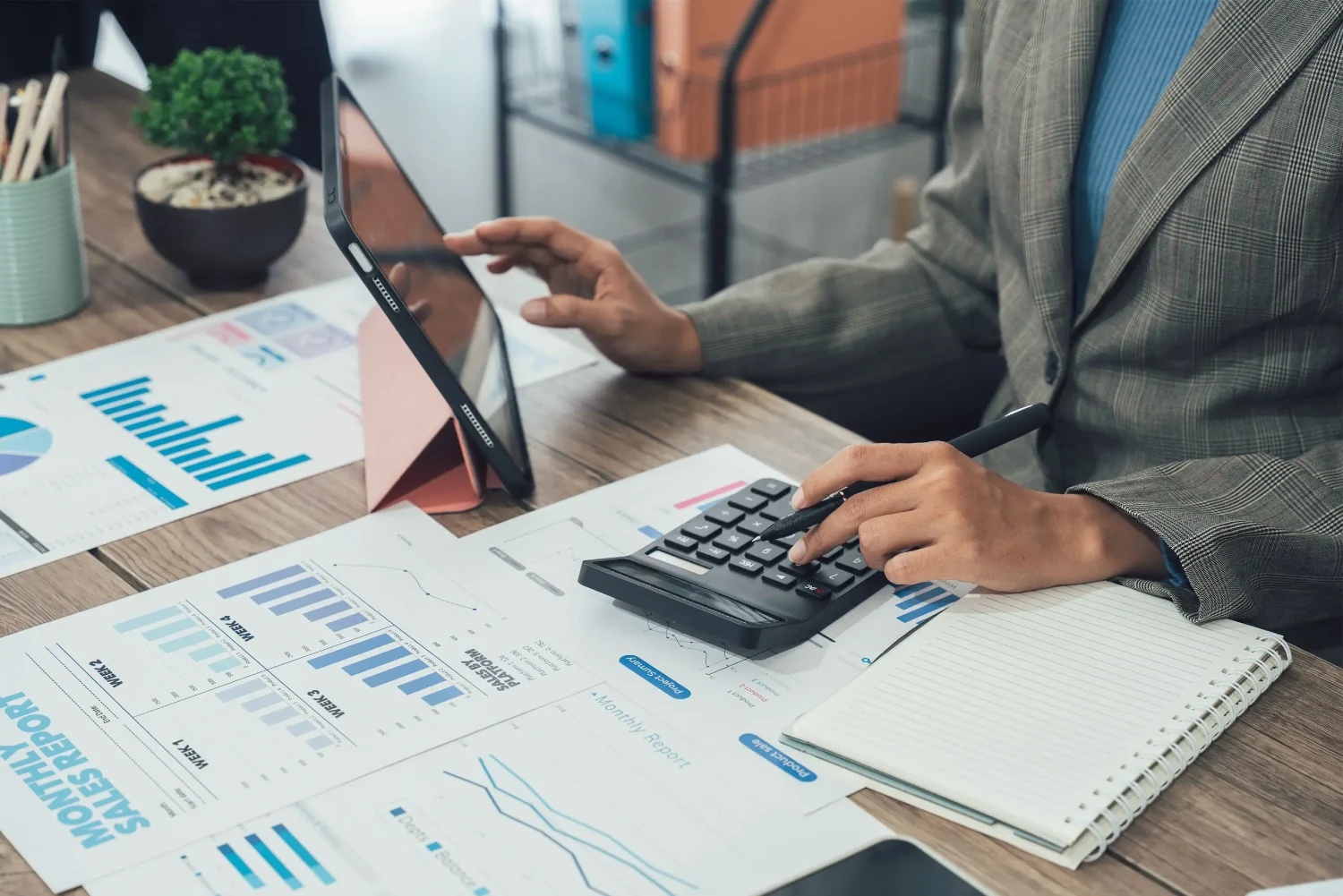 Person Bookkeeping with Calculator and Tablet