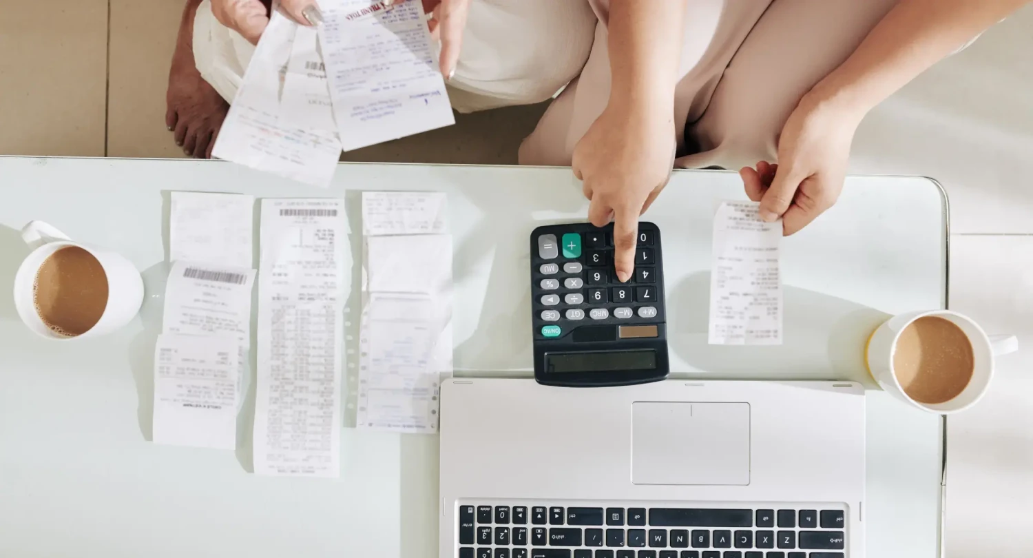 People Using Calculator and Laptop for Bookkeeping