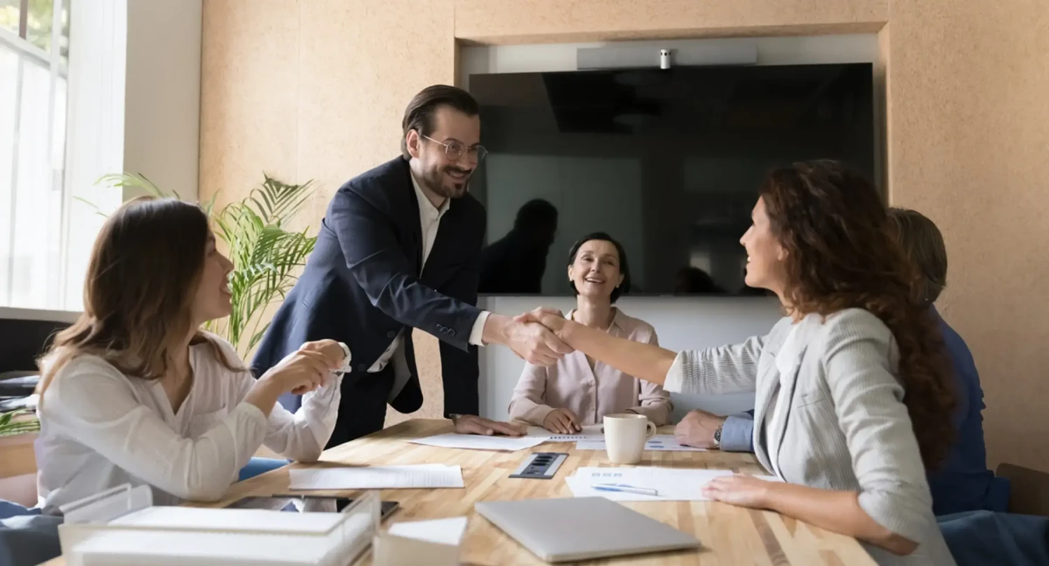 Man with Glasses Shaking Woman's Hand in Conference
