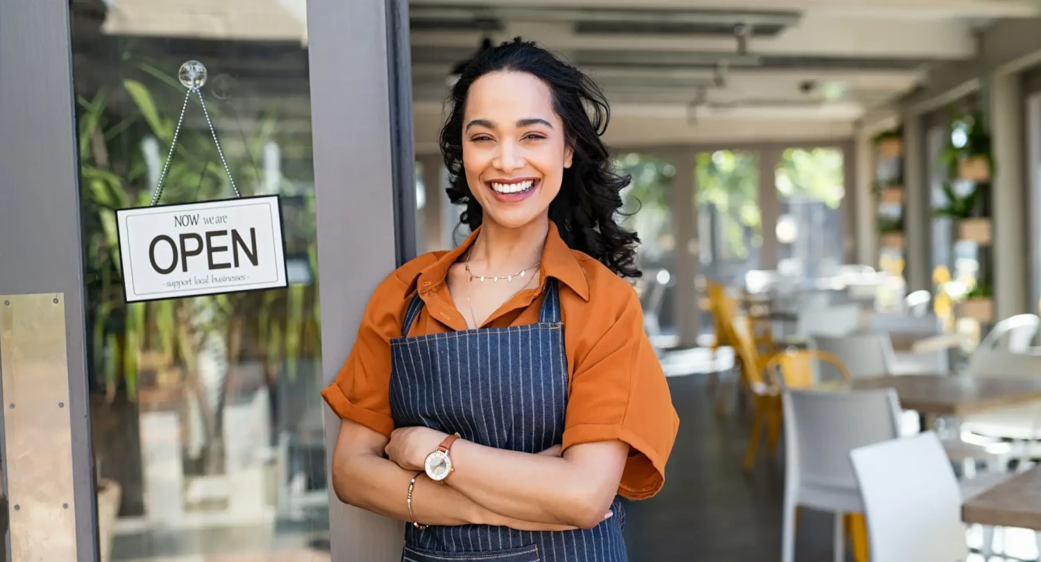 Woman in Apron in Front of Open Sign
