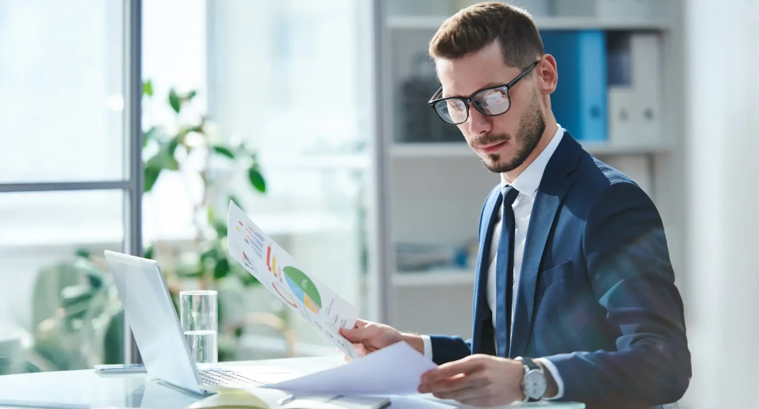 Man with Glasses Analyzing Charts